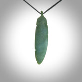 A hand carved large New Zealand Jade feather necklace. The cord is a black colour and is a fixed length. A large sized hand made Jade feather necklace by New Zealand artist Kerry Thompson. One off work of art to wear.